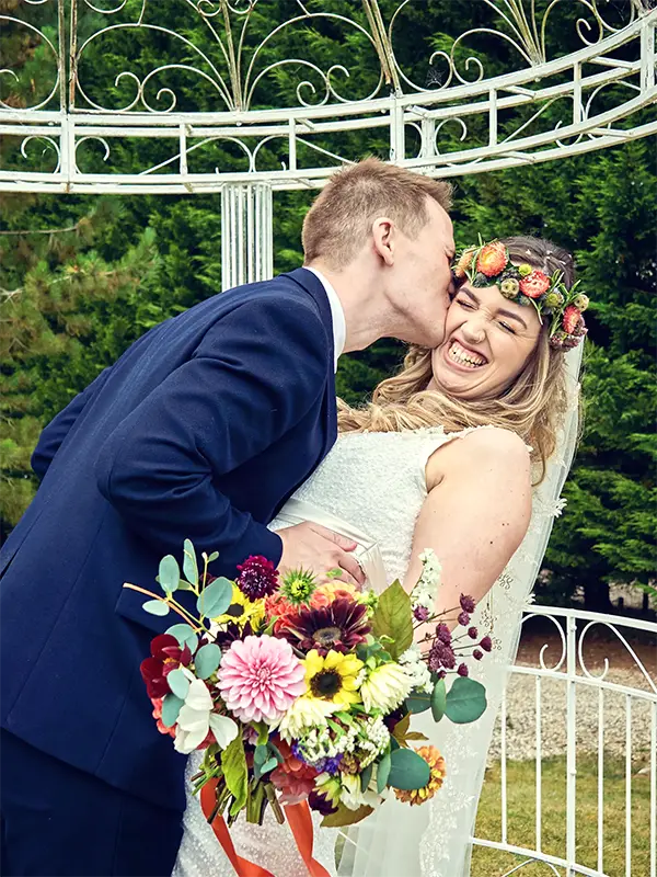 Groom kissing bride on cheek after their wedding in Worcester