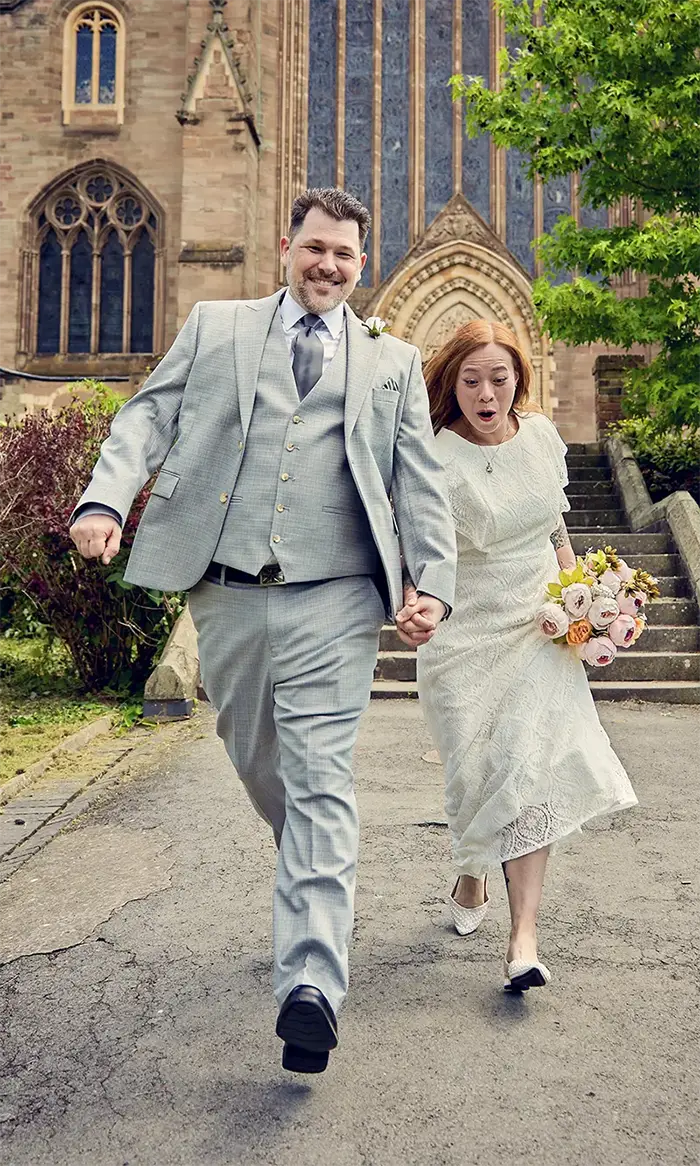 Newlyweds having fun outside Worcester cathedral